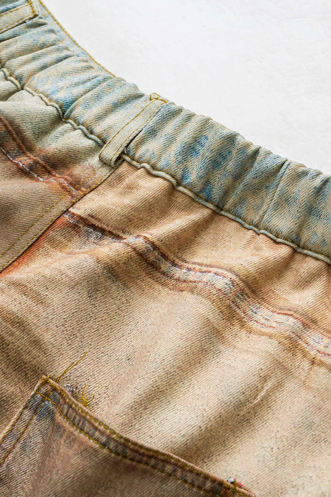 Kalhoty s kapsou a knoflíkem v abstraktním designu